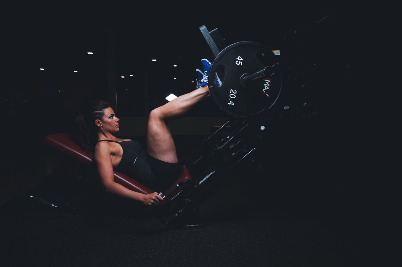 vrouw in sportkleding op een leg press machine