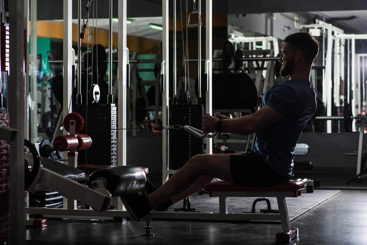 seated cable row in de sportschool door een man