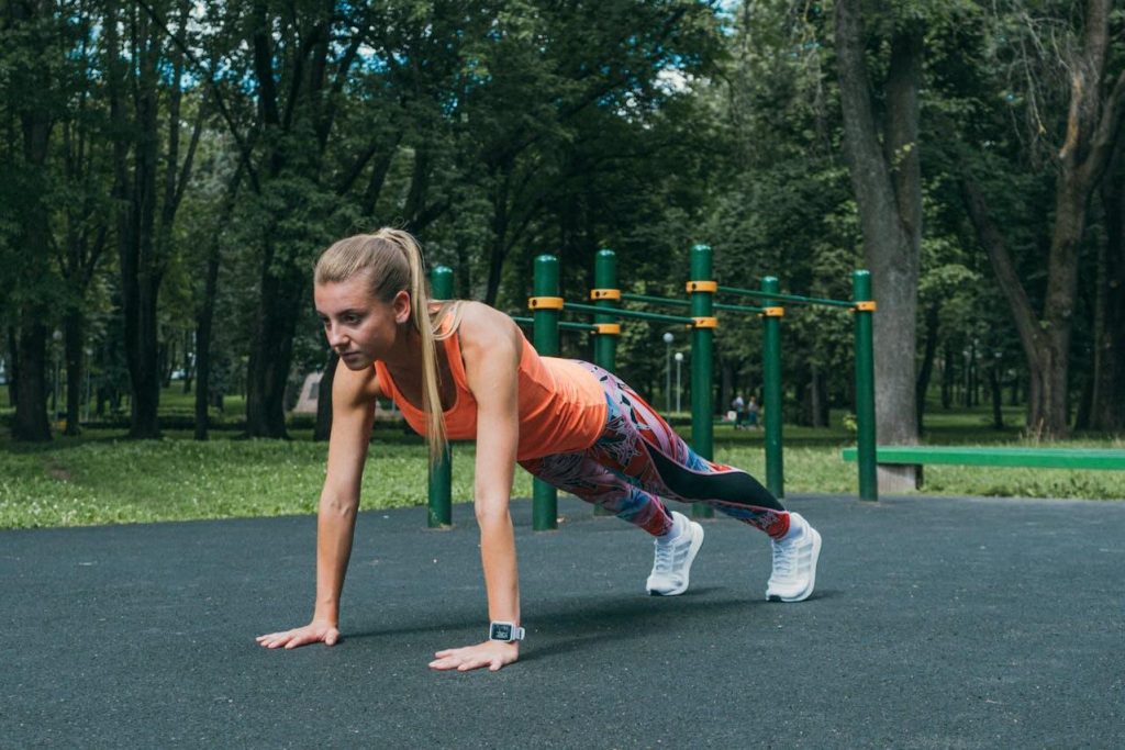 Vrouw doet een bodyweight workout met lichaamsgewicht push-ups in een park