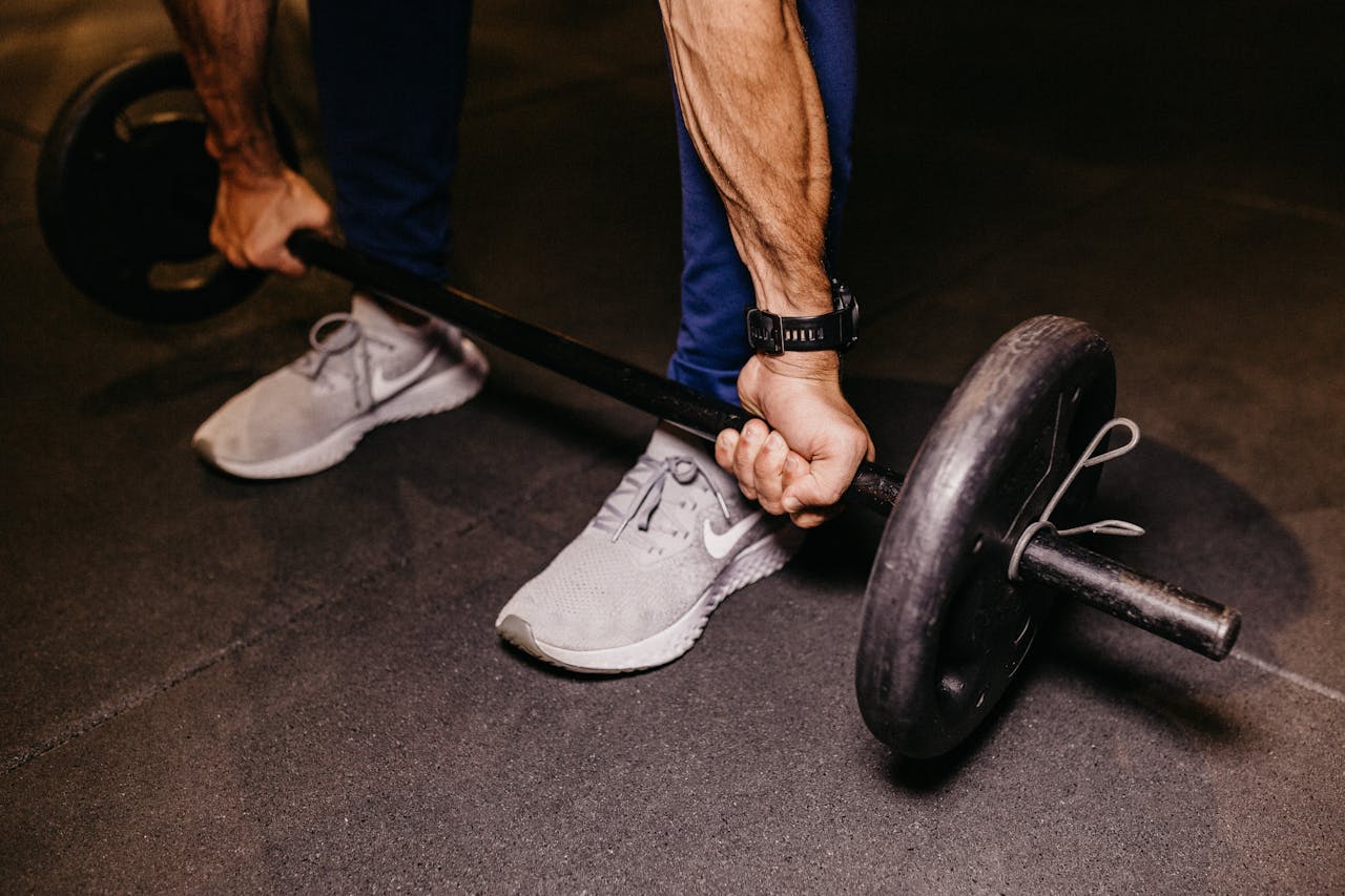 fitnessroutine thuis met een barbell en vloer van rubberen matten