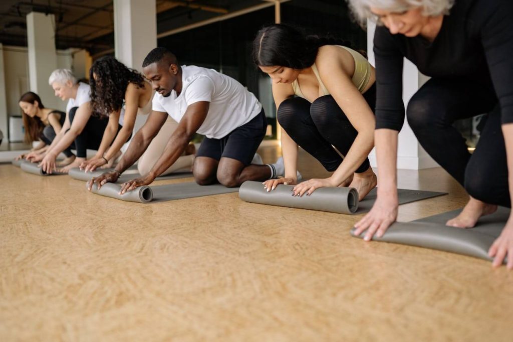 groep mensen aan het sporten in groepsverband met yogamatten