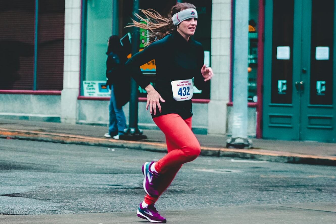 vrouw draaft hoofd zweetband tijdens hardlopen