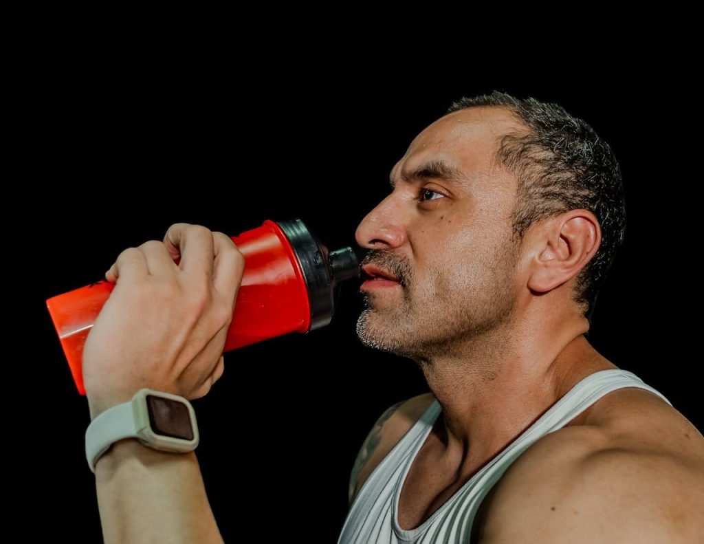 Man drinkt uit een rode shakebeker