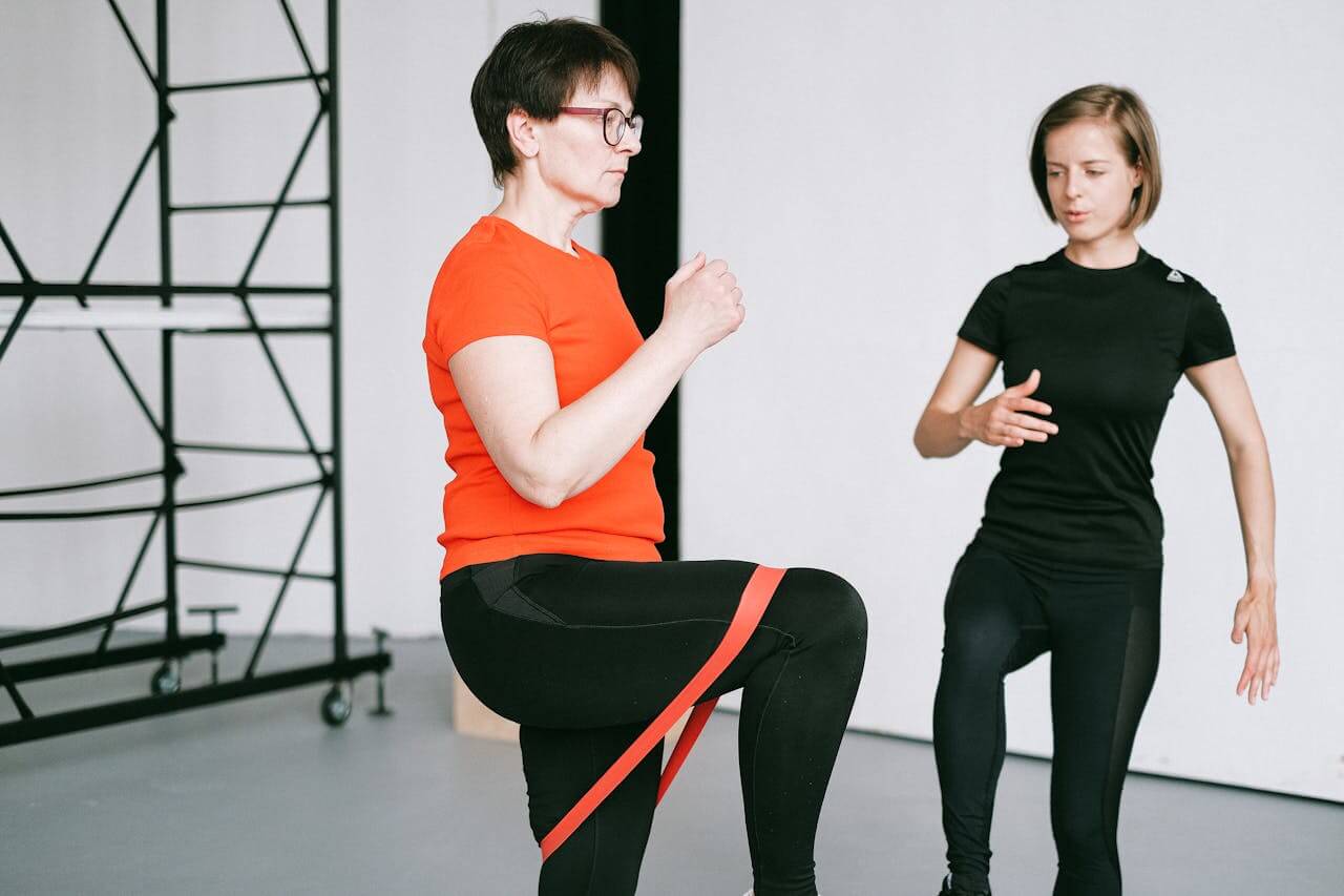 vrouwelijke personal trainer in zwart shirt is client in rood shirt aan het motiveren en trainen